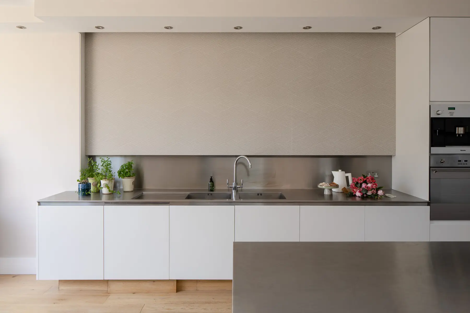 White handleless kitchen with a long worktop