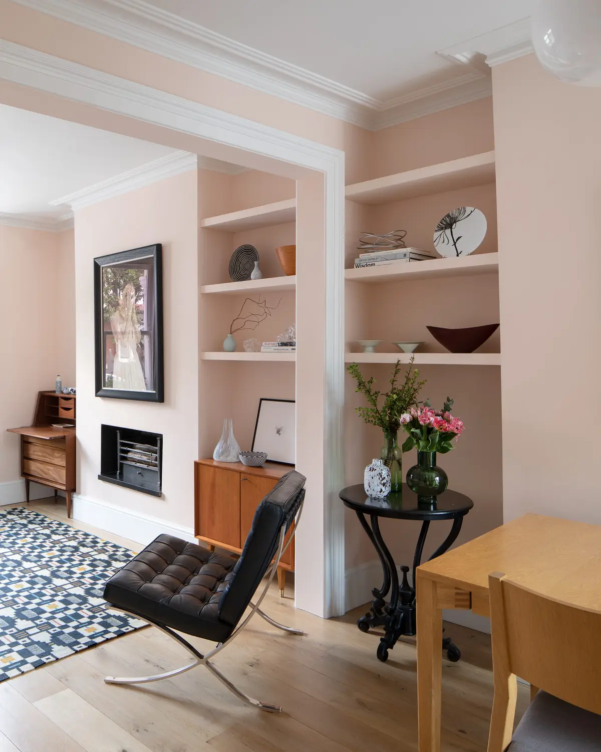 Living room with built-in alcove shelving and a geometric tiled hearth