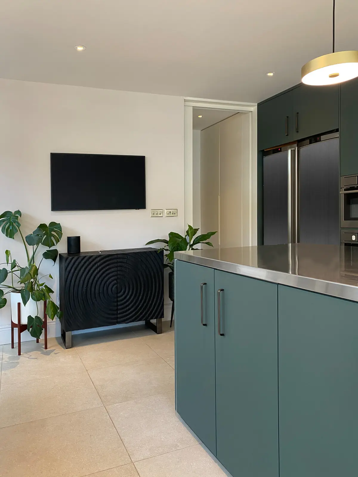 Black ribbed sideboard with a wall-mounted TV and plants