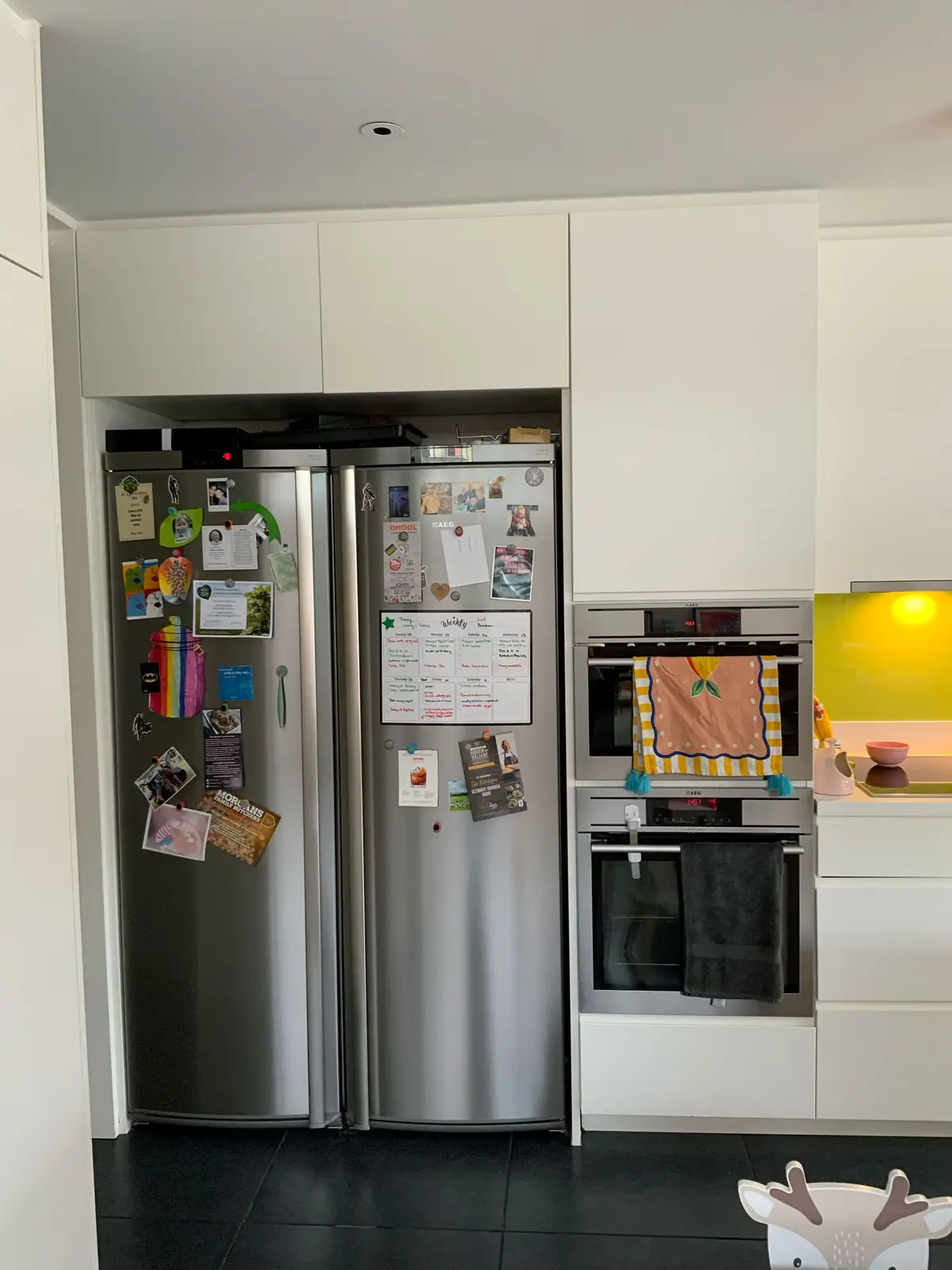 Kitchen appliance wall with a bright yellow splashback