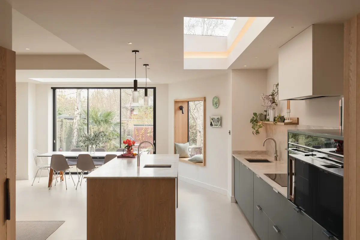 Kitchen extension with an oak island and pendant lights in a Crouch End home designed by JLV Design