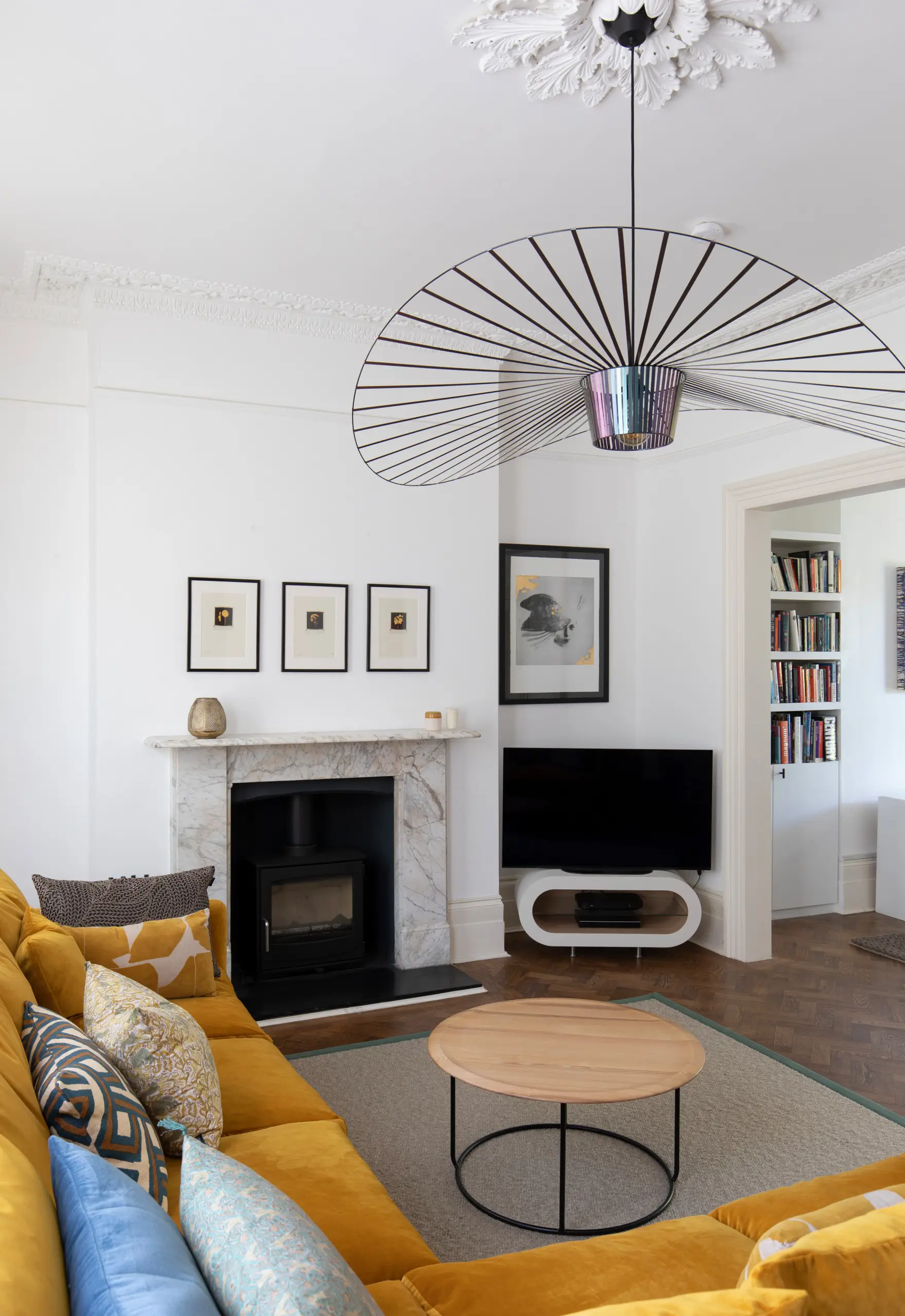 Marble fireplace with a stove and a gallery wall of black-and-white prints