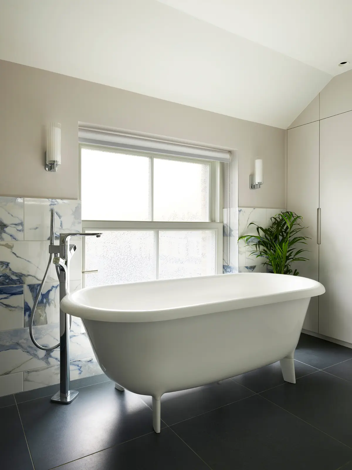 Bathroom with a freestanding bath beneath a large window