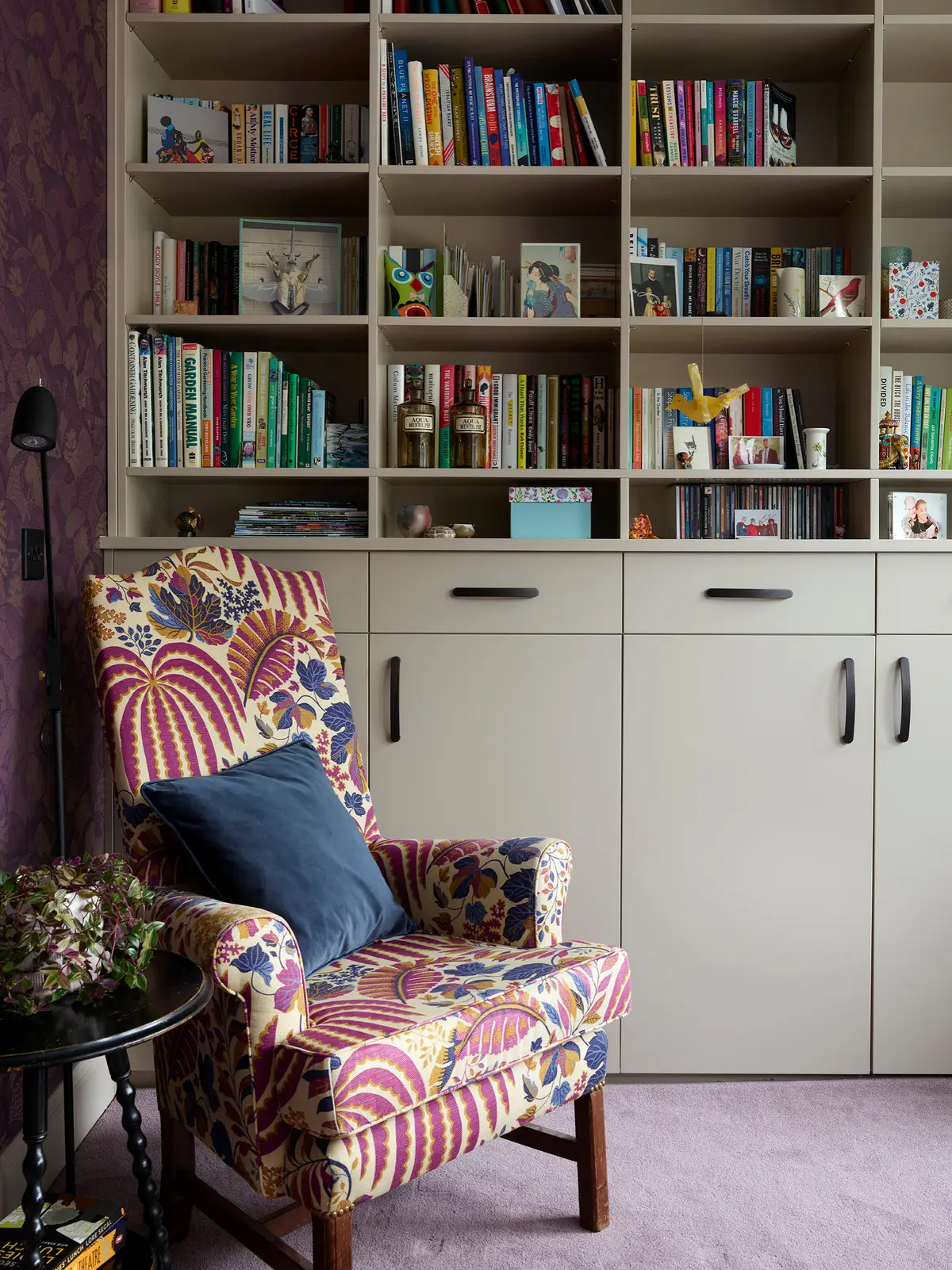 Family room with built-in cupboards, bookshelves and a patterned armchair