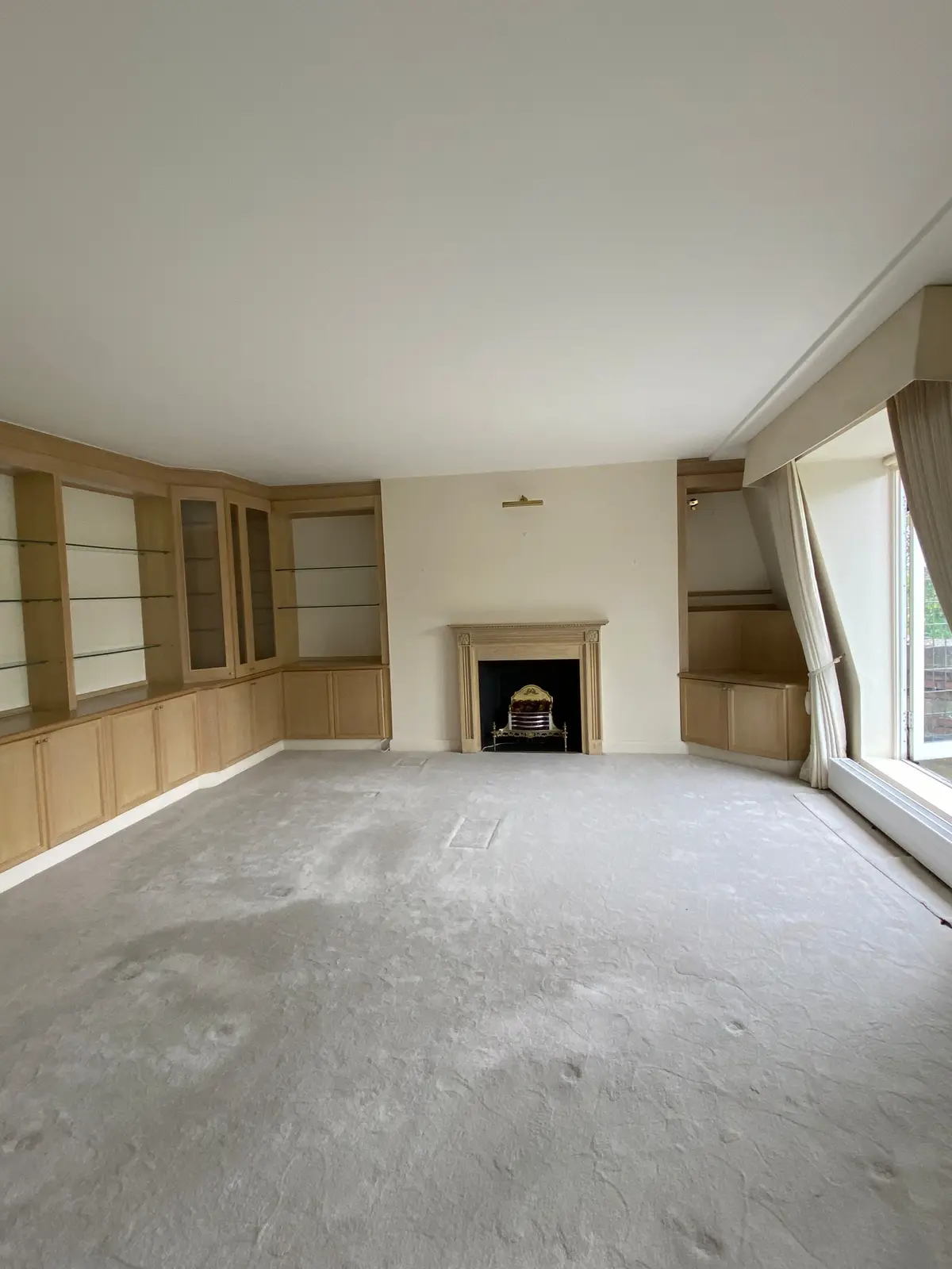 Unfurnished living room with a fireplace and built-in shelving