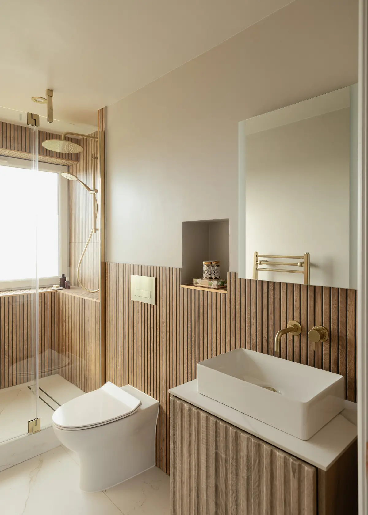Bathroom with oak slatted panelling and brushed brass fittings