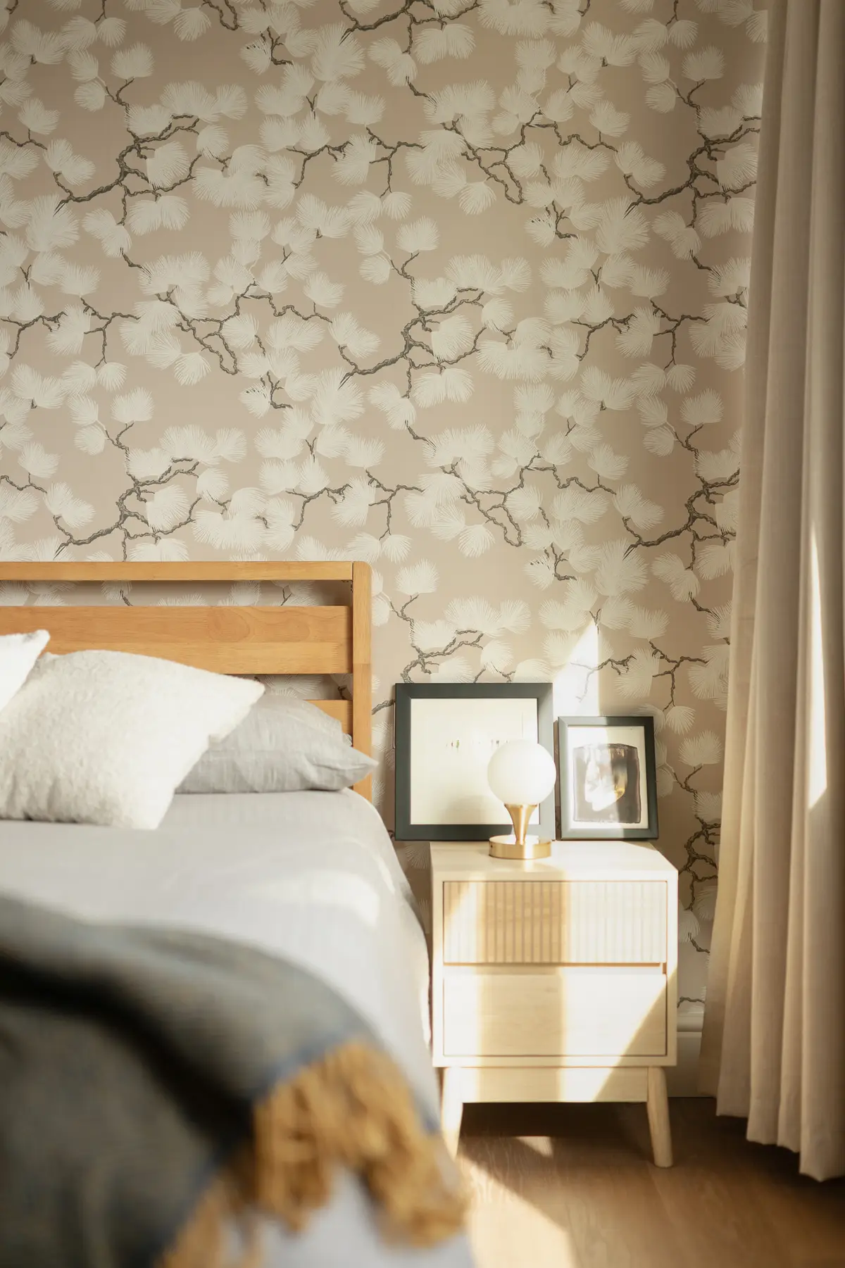 Bedroom with an oak bed frame and soft patterned wallpaper