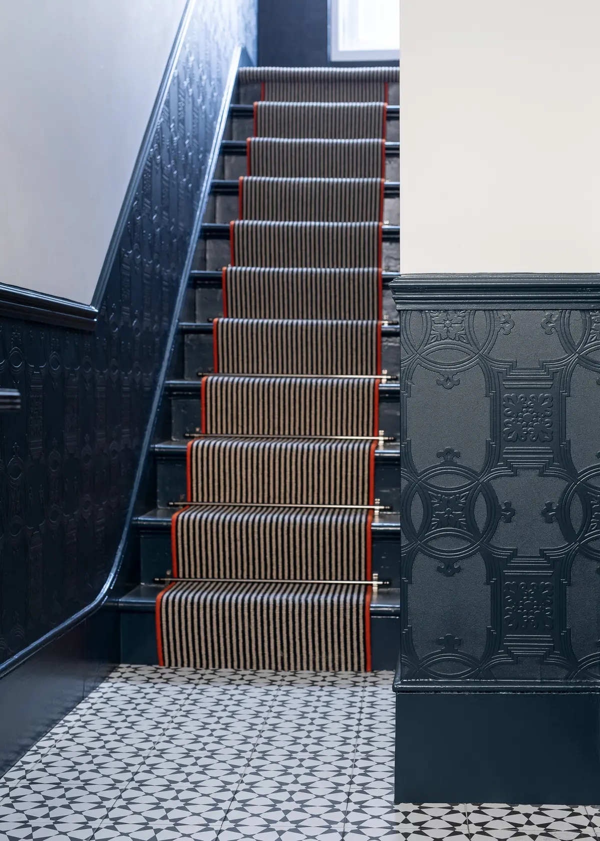 Navy stair runner with orange edging and a navy patterned wallpaper, Finsbury Park