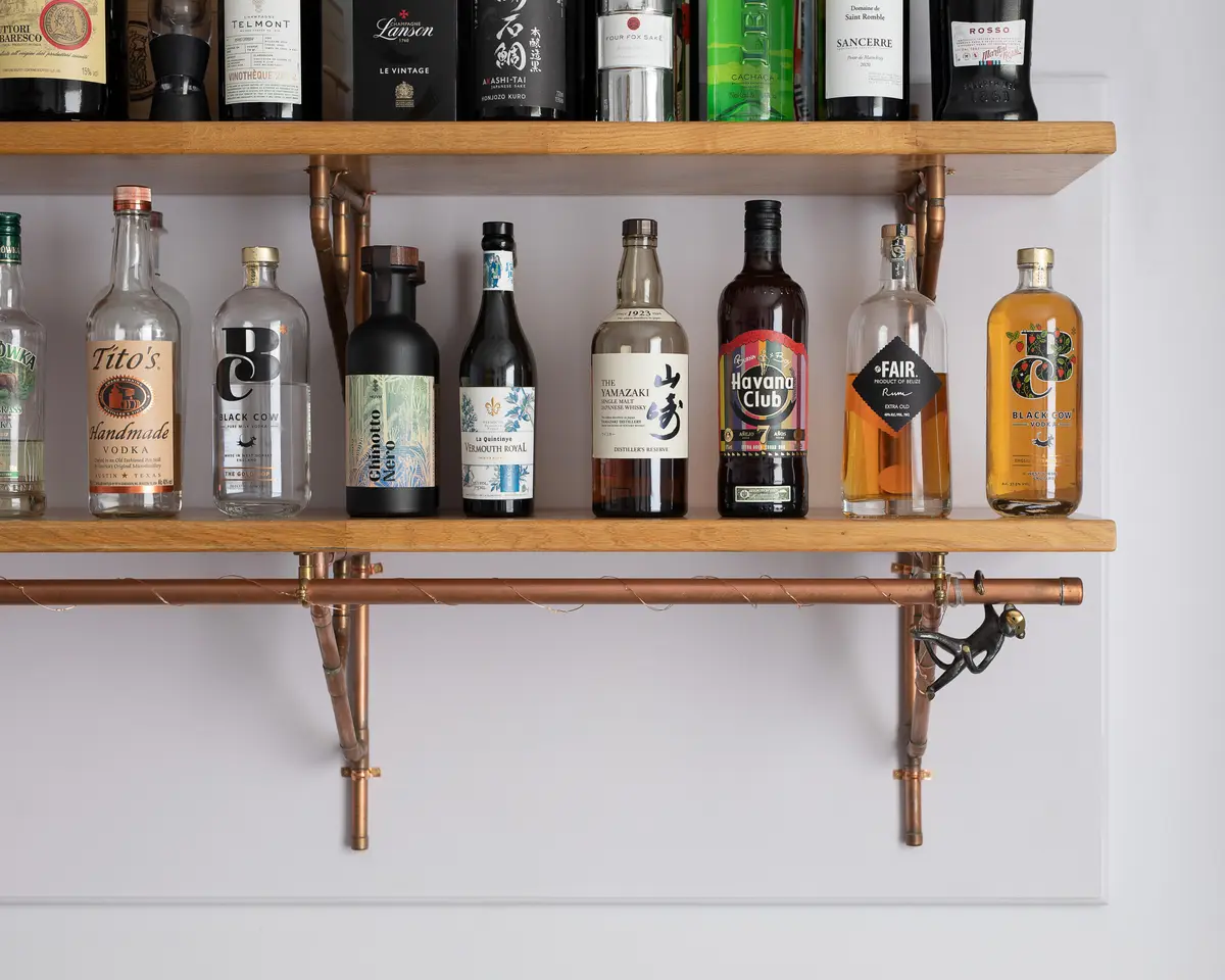 Reclaimed timber shelves with bottles on copper brackets
