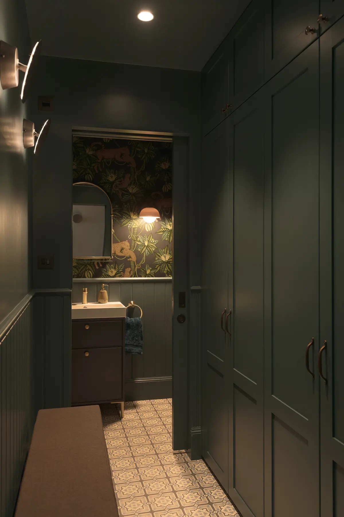 Dark green cloakroom with a moody floral wallpaper