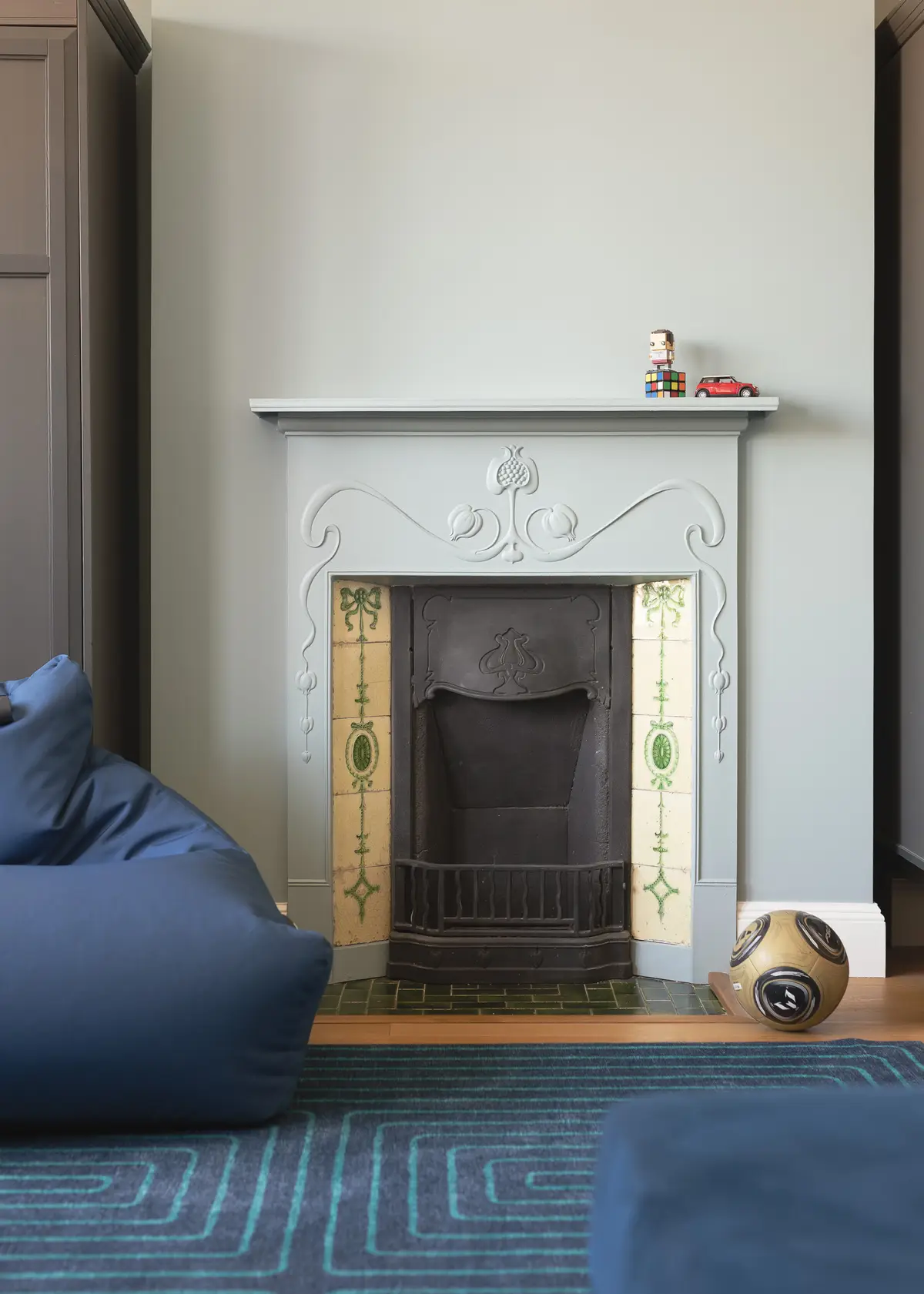 Restored cast-iron Victorian fireplace with a decorative tiled surround