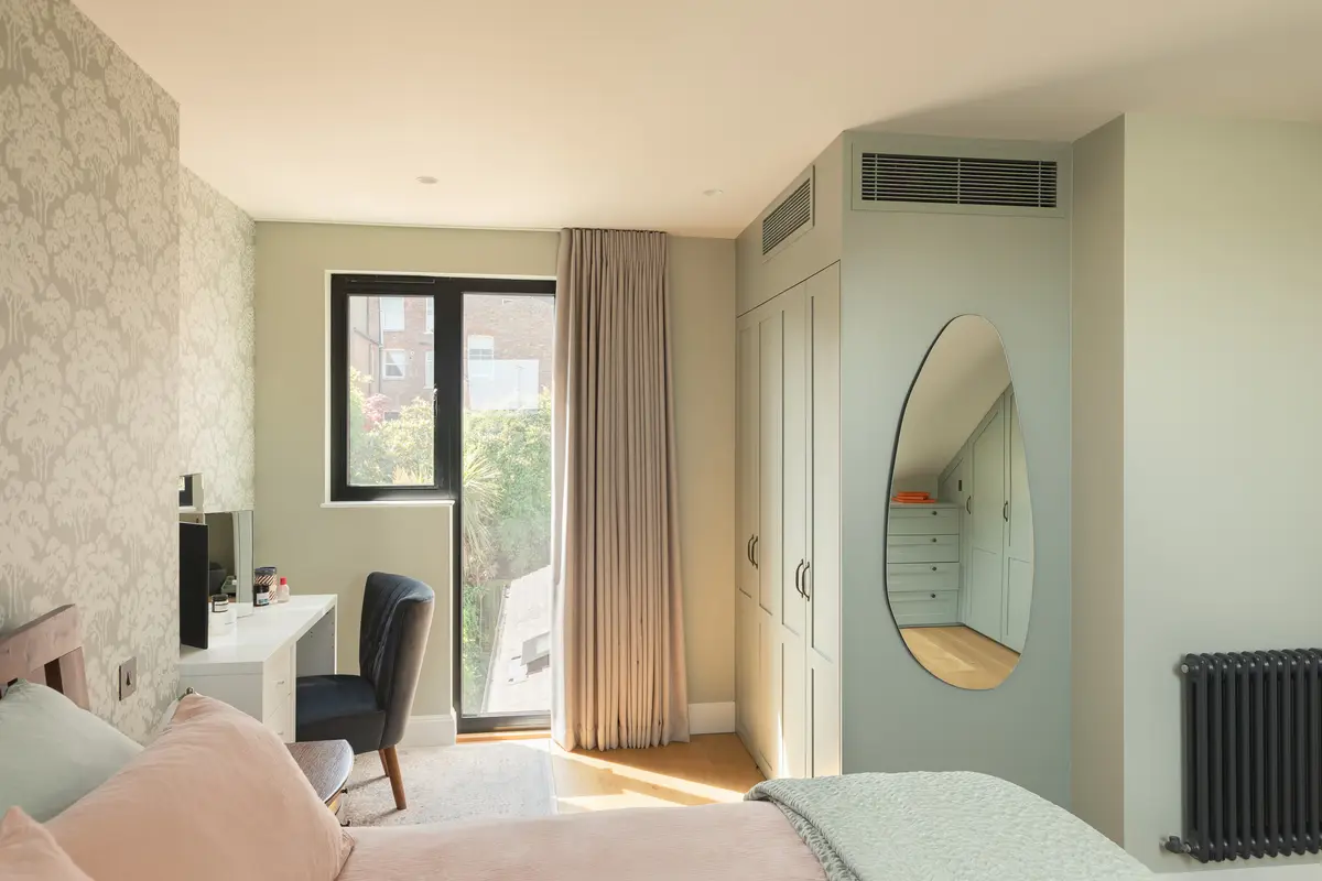 Main bedroom with deep green walls, a wallpapered alcove and an oval mirror, Alexandra Palace